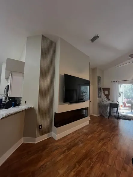 Fireplace feature wall with a hand-built wood slat column and a wall-mounted TV